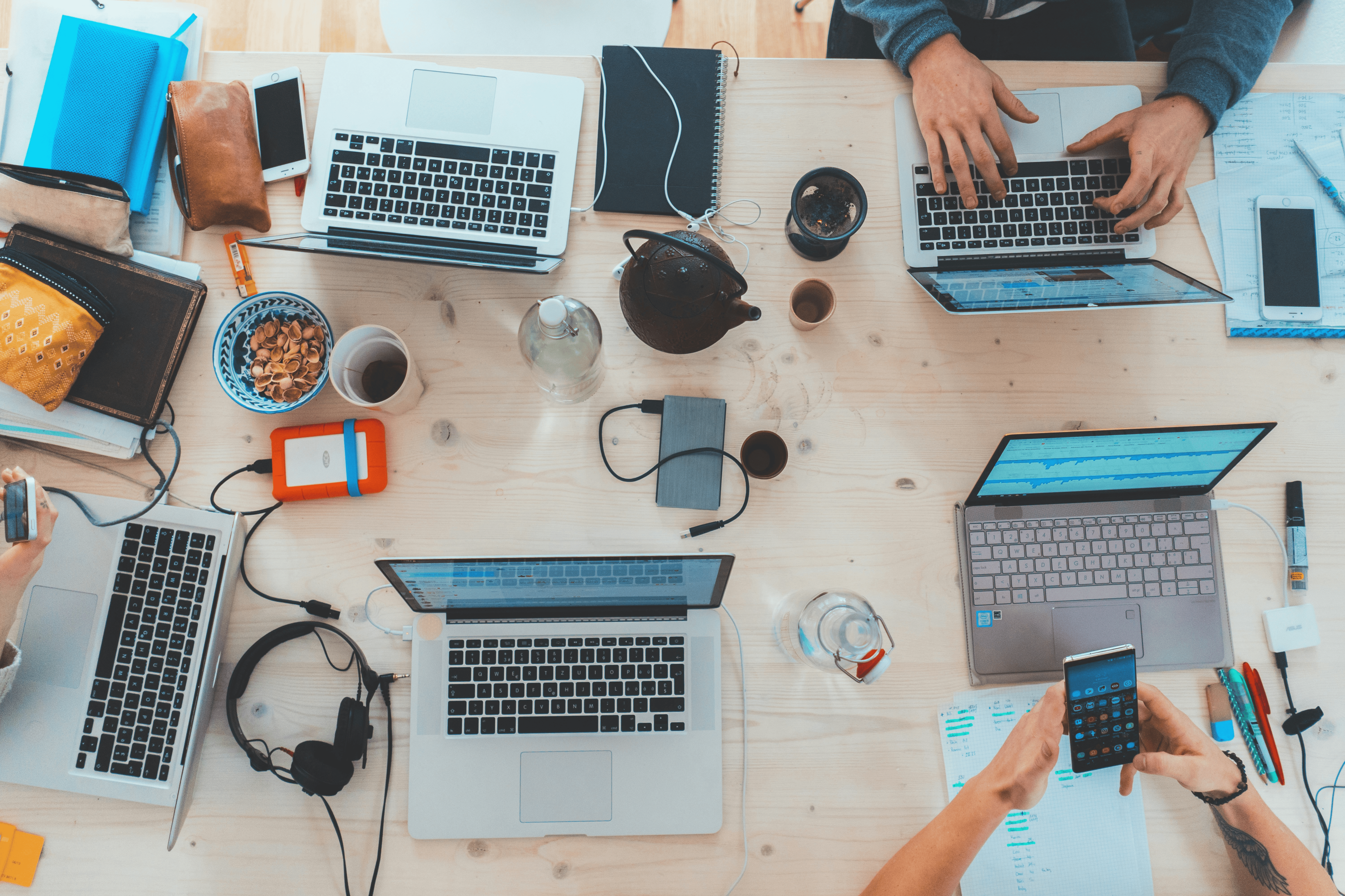 Image shows a bank of laptops all set up around a desk, showing a hot desking environment, where people work